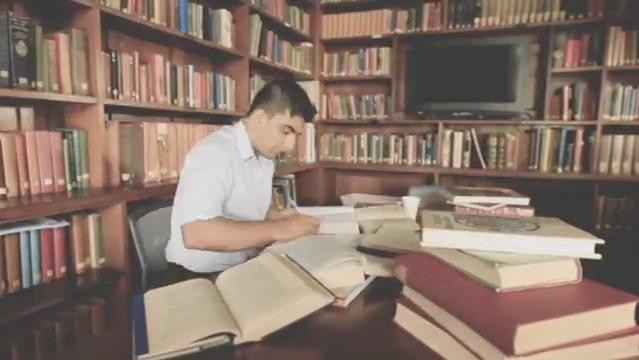 Akram Azimi sits in library at deak