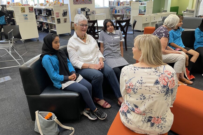 Grandmothers sit and speak to students.