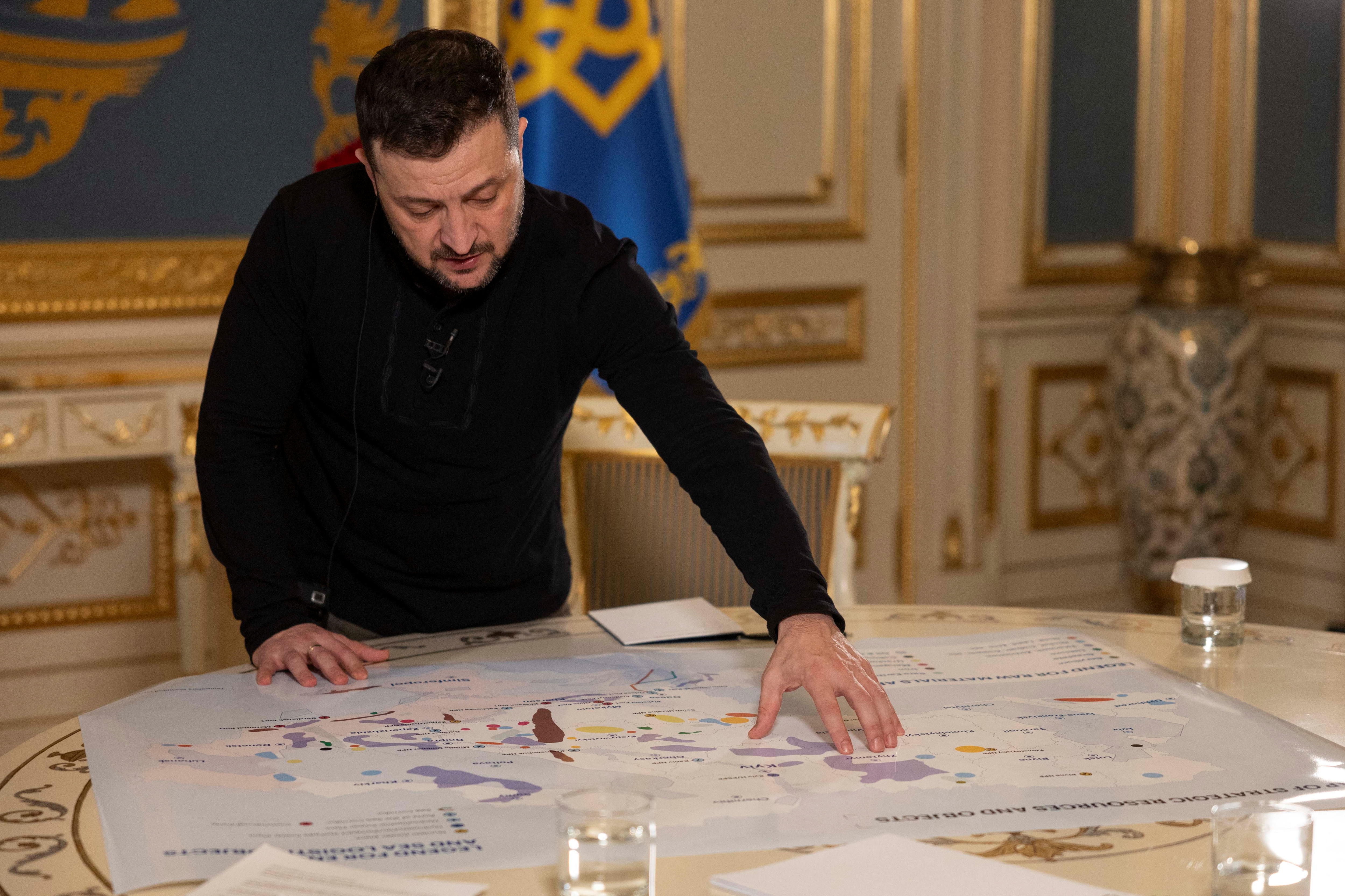Ukraine's President Volodymyr Zelenskiy shows journalists a map 