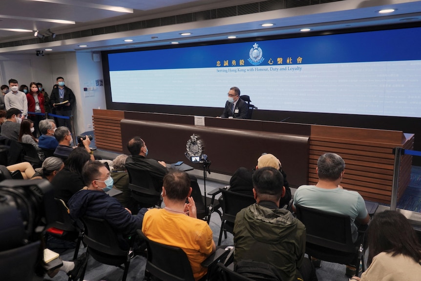 Seated police officer speaks at news conference.