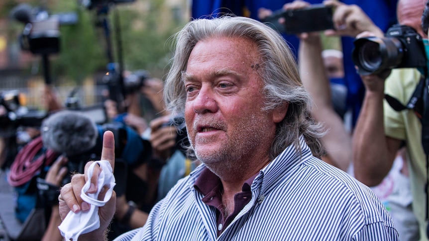 Steve Bannon gestures while speaking in front of reporters