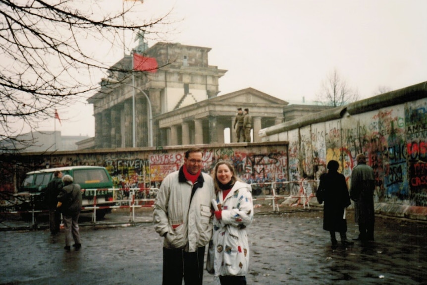 Peter Ryan and his wife stand in front of the Berlin Wall in November 1989.