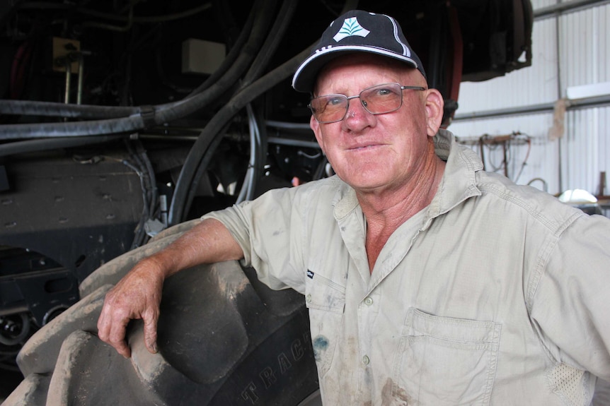 Ray Harrington stands, leaning on a tractor tyre