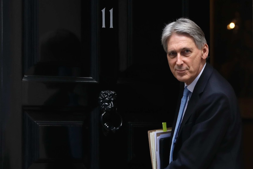 Chancellor Philip Hammond wearing a suit leaving 11 Downing Street