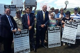 New South Wales Labor leader Luke Foley with protesters holding placards against forced council amalgamations.