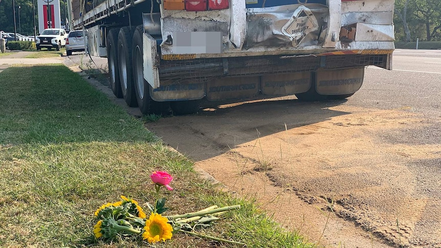 Flowers left on footpath behind the truck that a teacher crashed his car into and died.