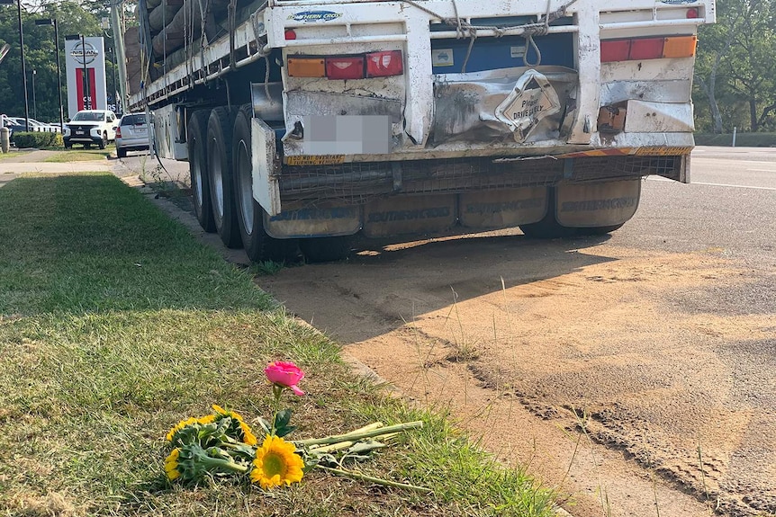 Flowers left on footpath behind the truck that a teacher crashed his car into and died.