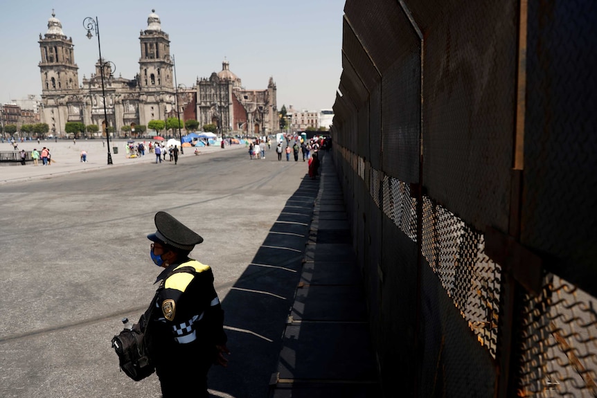 A policeman stands by a barricade in an open square