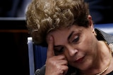 Dilma Rousseff rests her head against her hand.