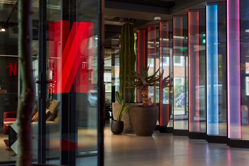The interior of office with a neon Netflix sign insid