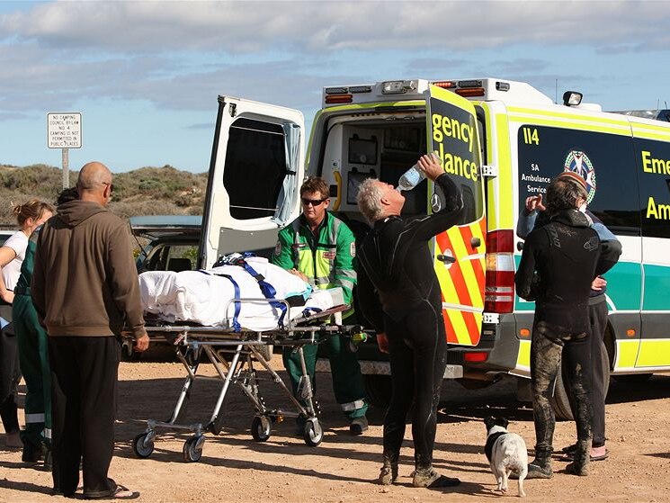Other surfers carried the man up dunes to a waiting ambulance