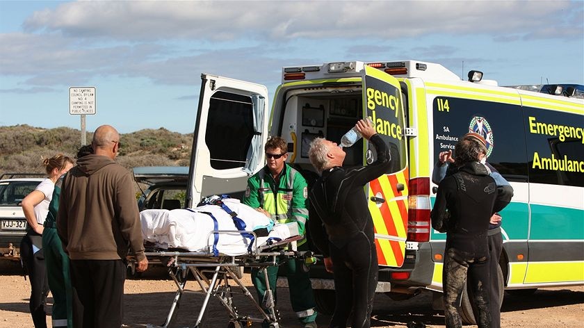 Other surfers carried the man up dunes to a waiting ambulance