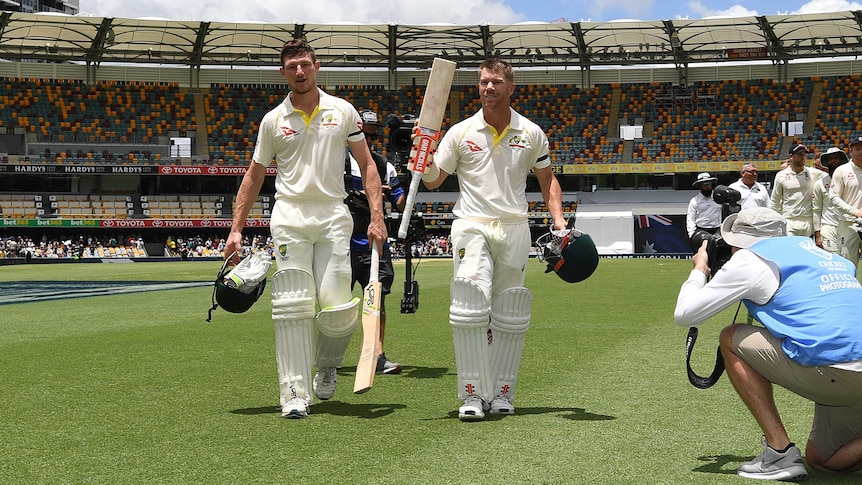 Australia's David Warner (R) and Cameron Bancroft walk off the Gabba after the first Ashes Test.