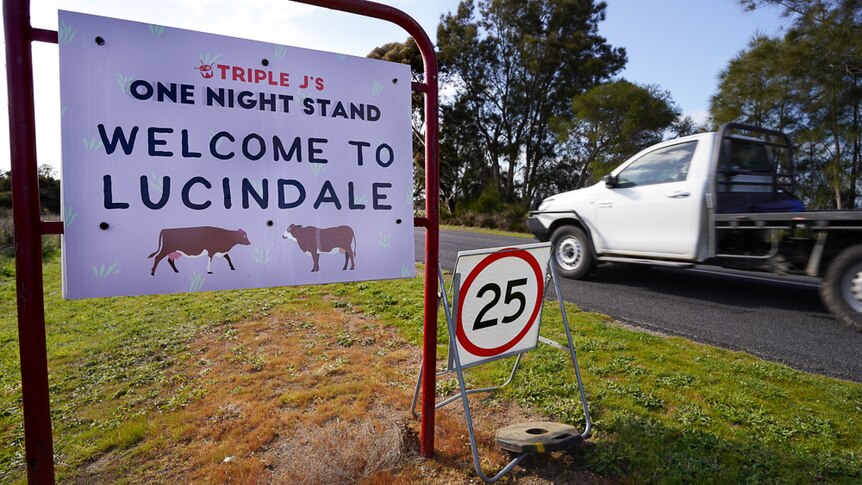 A white ute entering Lucindale passes a Welcome to One Night Stand sign.