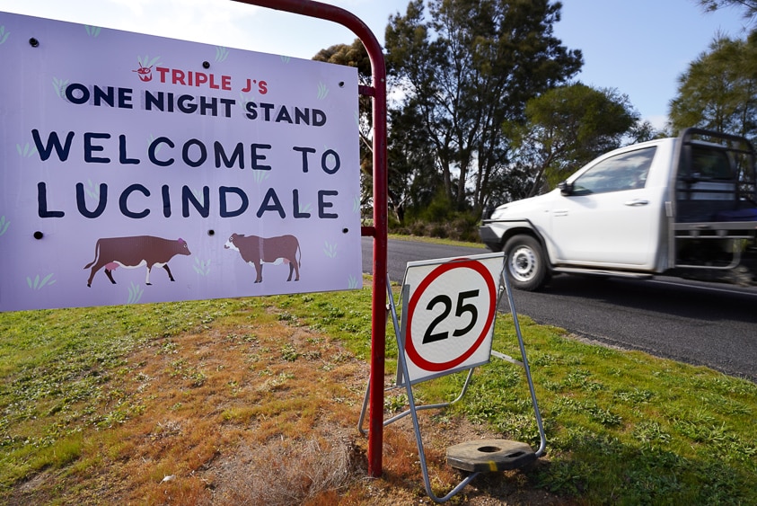 A white ute entering Lucindale passes a Welcome to One Night Stand sign.