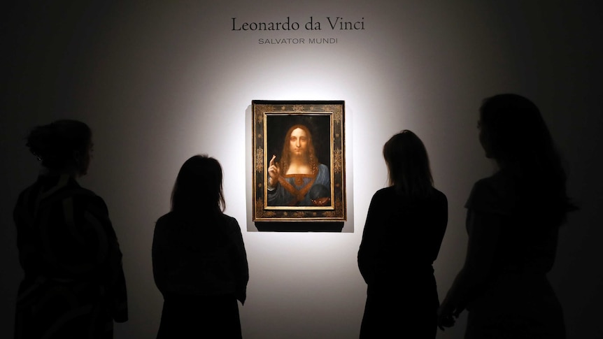 People gather around Leonardo Da Vinci's Salvator Mundi