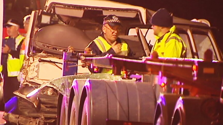 Police with the van that hit the back of the truck