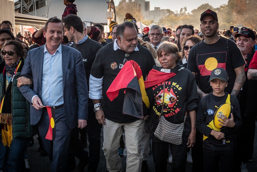 Former Australian rules star Michael Long talks to Indigenous marchers, as WA premier Mark McGowan walks next to him.