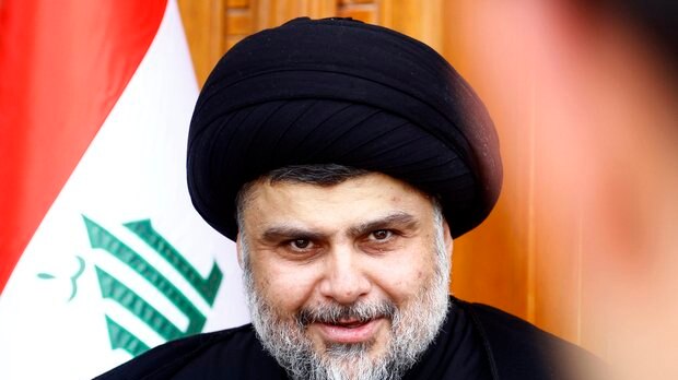 Close portrait of populist Iraqi cleric Moqtada al-Sadr in front of the Iraqi flag