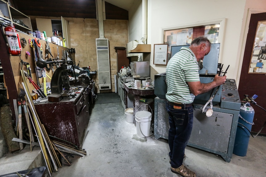 John Flynn with the $27,000 Italian casting machine that arrived in 1978 and is still used today.