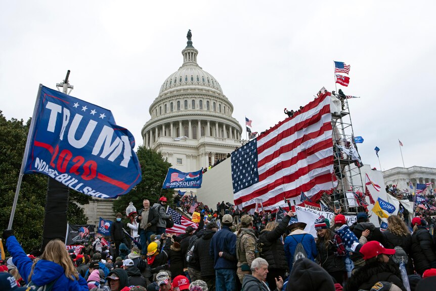 Protesters wave American and Trump flags outside the US Capitol building.