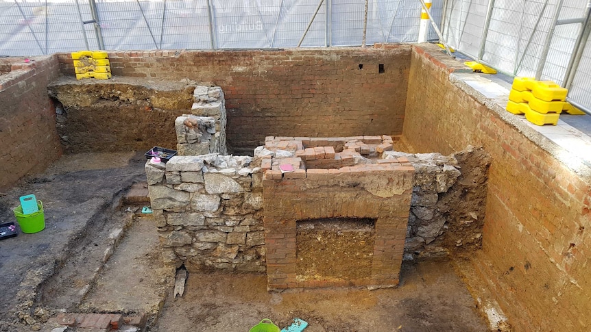 The Lonsdale Street Melbourne archaeological dig showing brick fireplace, stone walls and excavation