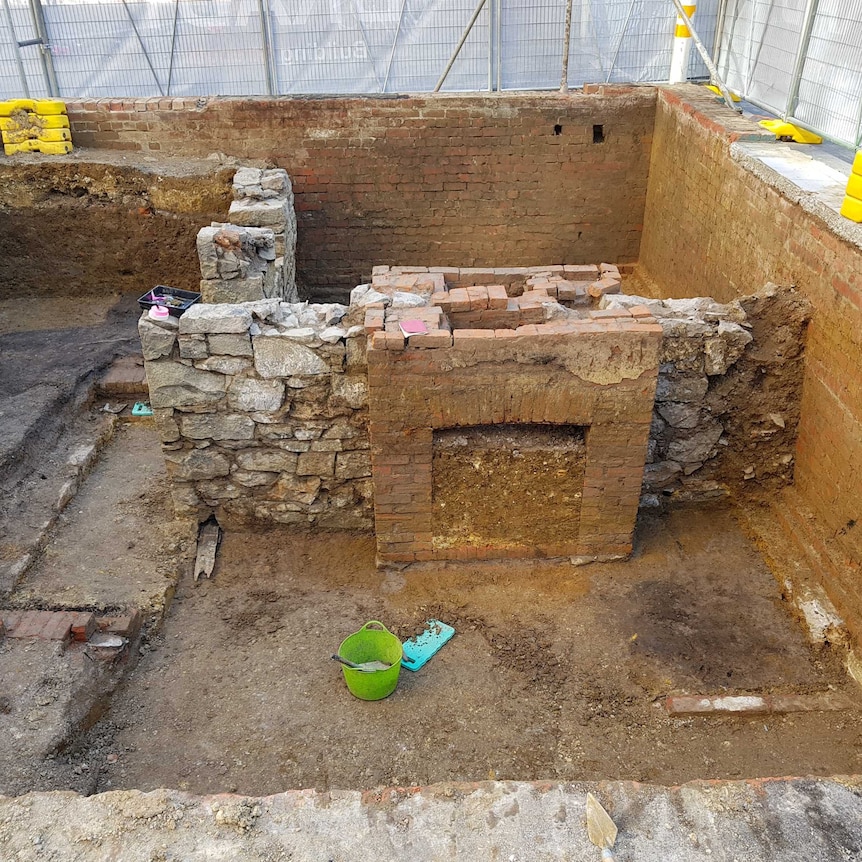 The Lonsdale Street Melbourne archaeological dig showing brick fireplace, stone walls and excavation