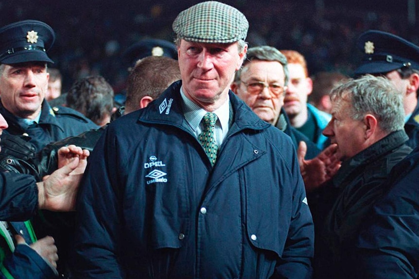 Jack Charlton looks dapper in his hat and coat while police and fans surround him