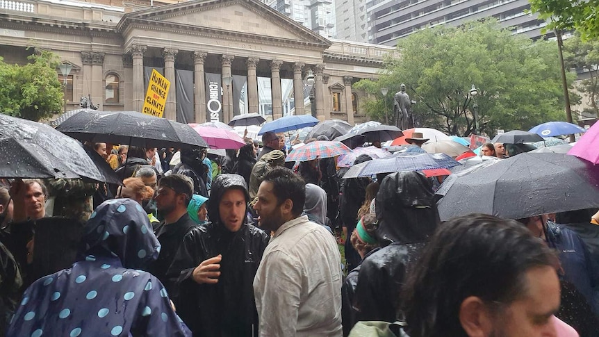 Protesters gather in rain at Melbourne climate rally.