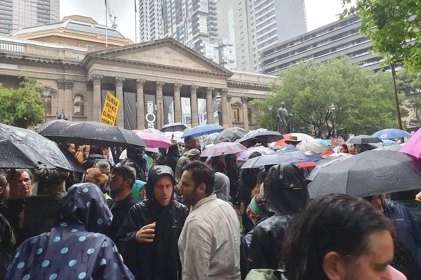 Protesters gather in rain at Melbourne climate rally.