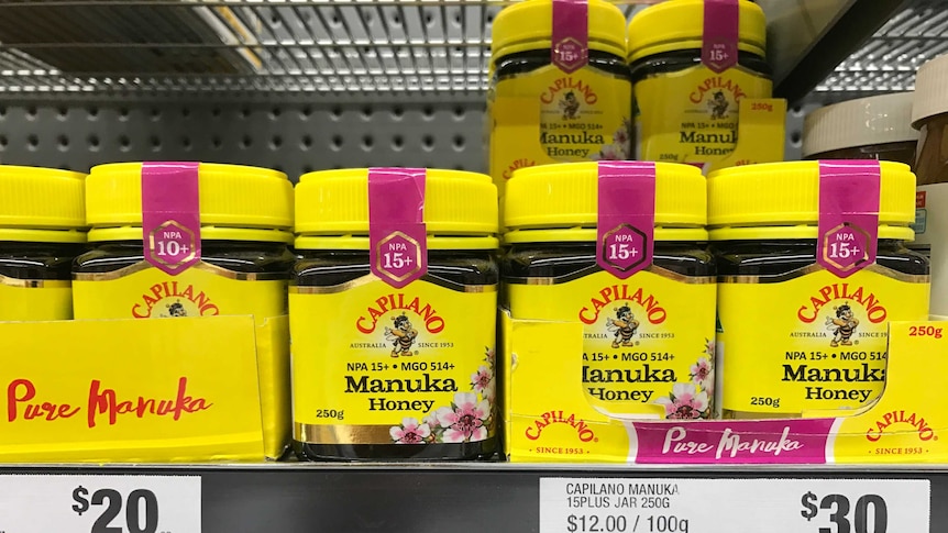 yellow jars of Manuka honey on a supermarket shelf