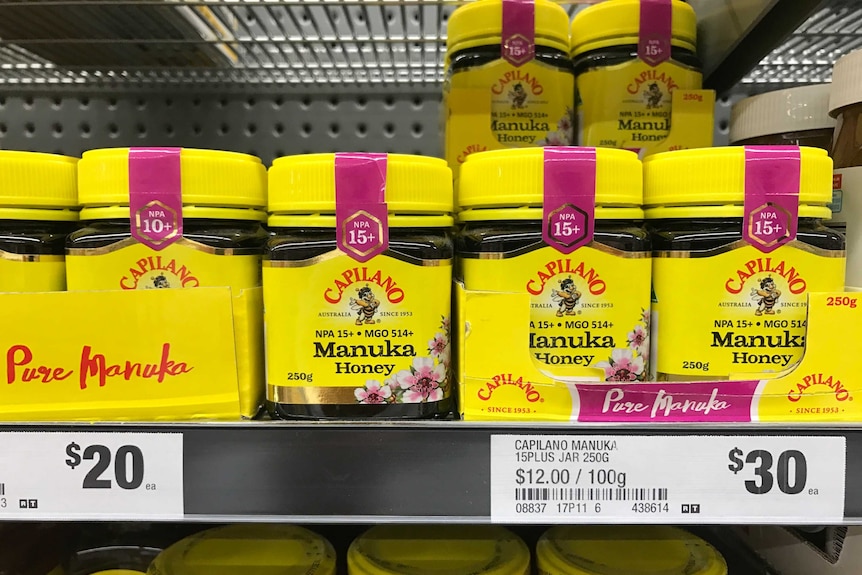 yellow jars of Manuka honey on a supermarket shelf