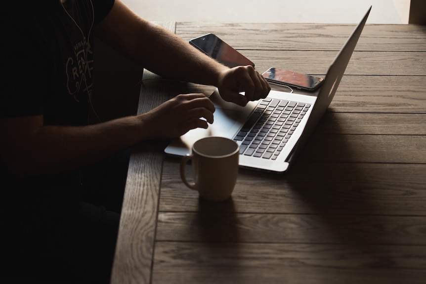 An open laptop with someone typing on it