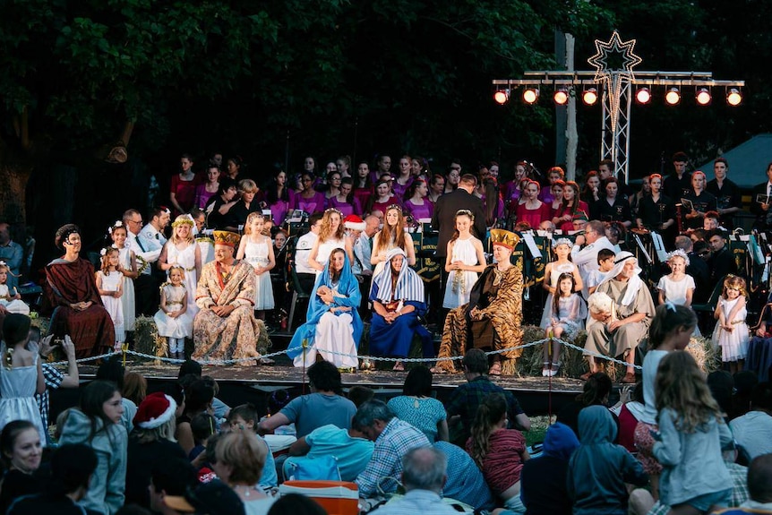 Participants on stage performing a scene at Christmas carols