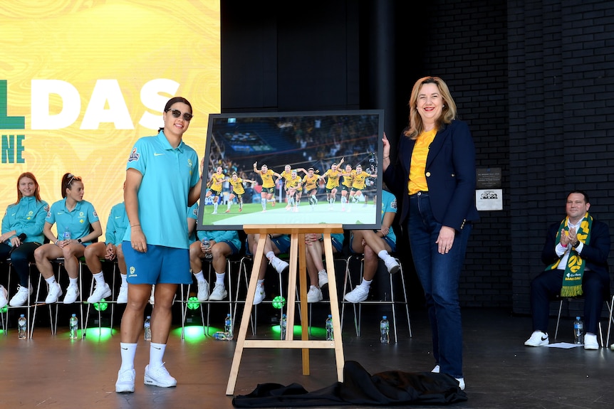 Sam Kerr wearing sunglasses with a photo of the Matildas and Annastacia Palaszczuk.