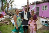The Naidu family stand in front of their house after Cyclone Winston