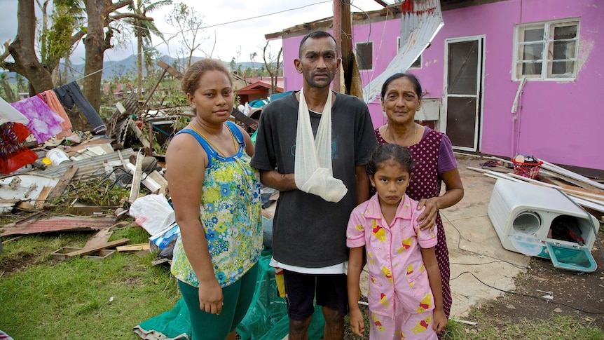The Naidu family stand in front of their house after Cyclone Winston