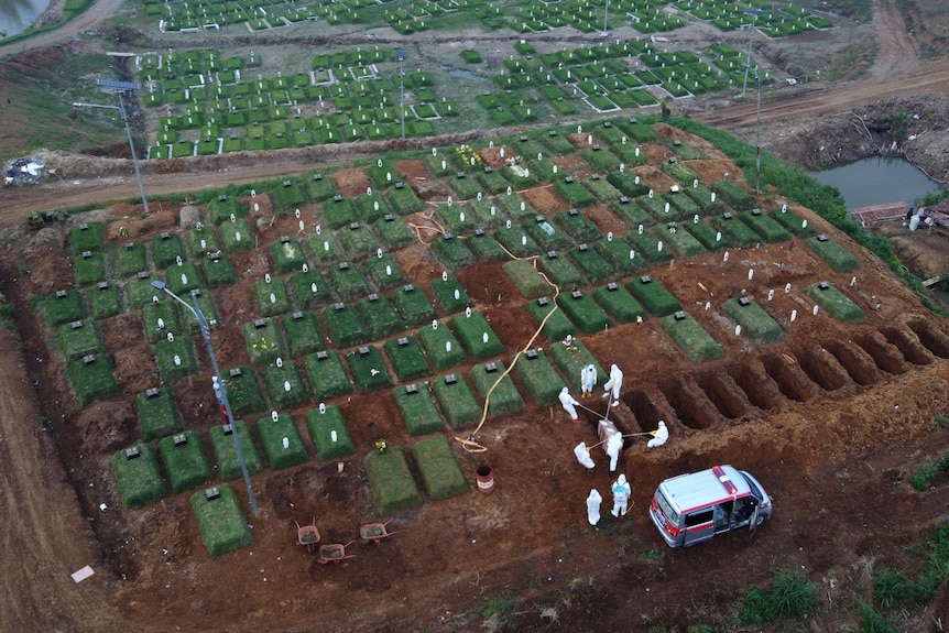 An aerial shot shows workers burying a COVID-19 victim at a dedicated cemetery