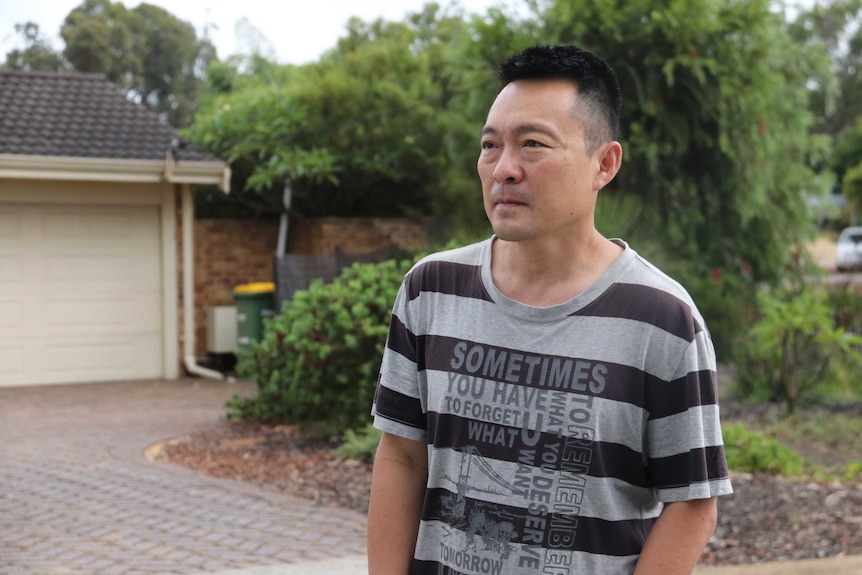 Kenneth Cheok standing outside the front of a suburban house