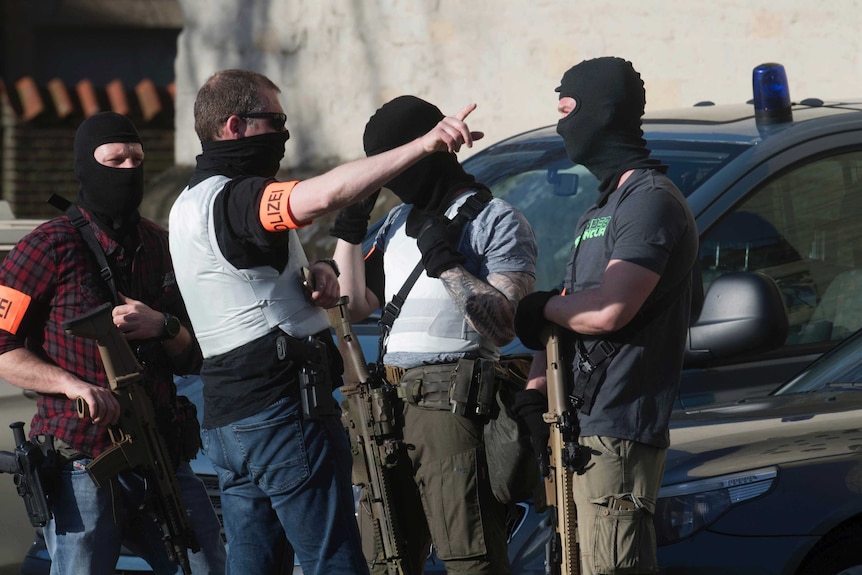 A special police force is seen dressed in civilian clothes and masks carrying rifles.