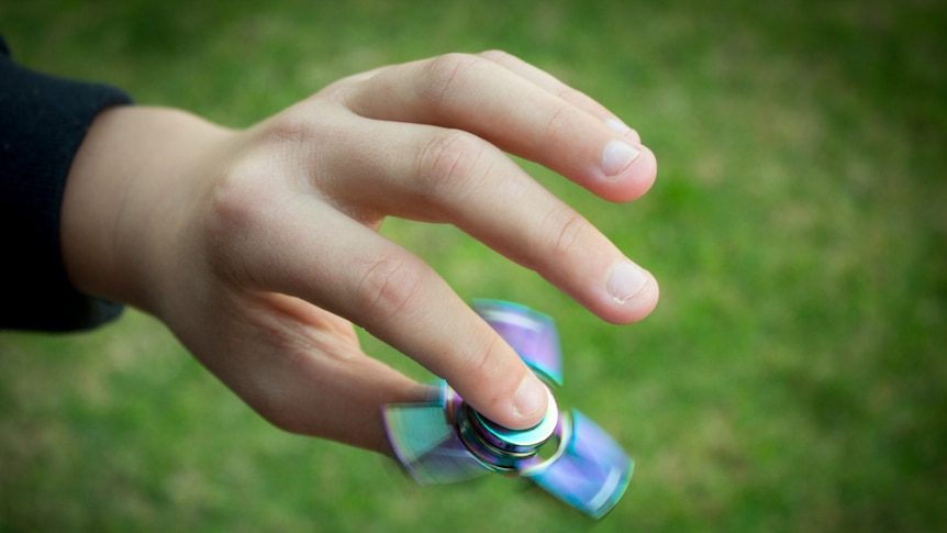 A fidget spinner being spun in a child's hand.