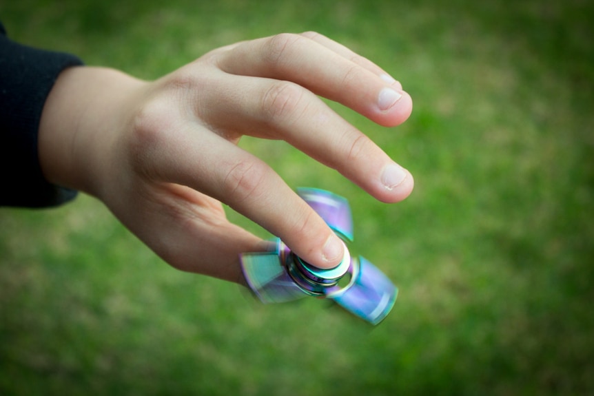 A fidget spinner being spun in a child's hand.