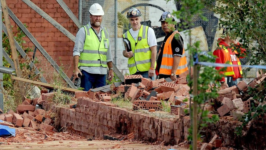 Construction workers gather near the scene of a fatal Melbourne wall collapse