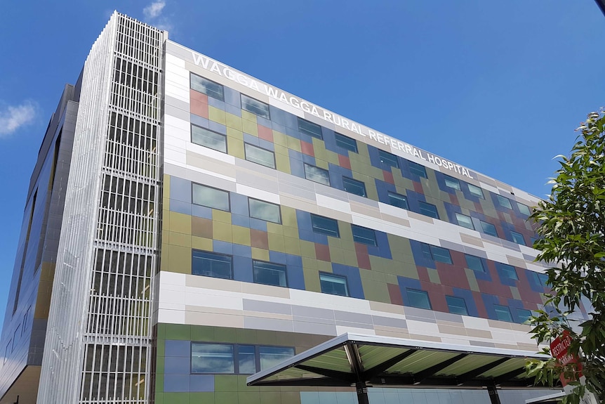 The exterior of a hospital building with coloured windows reflecting sunlight