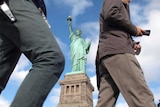 People walk past the Statue of Liberty after it re-opened.