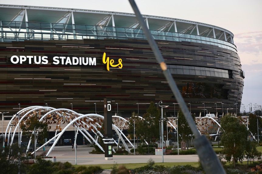 The front side of Perth Stadium close up as seen from the Matagarup Bridge showing the arched walkway at dusk