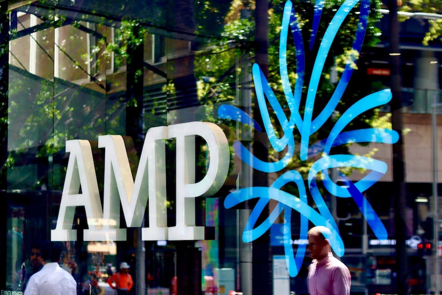 AMP logo in the window of the wealth manager and bank's Sydney CBD branch, with people reflected in glass.