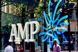 AMP logo in the window of the wealth manager and bank's Sydney CBD branch, with people reflected in glass.
