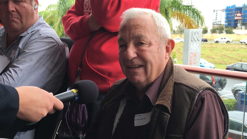 older male speaking into microphone