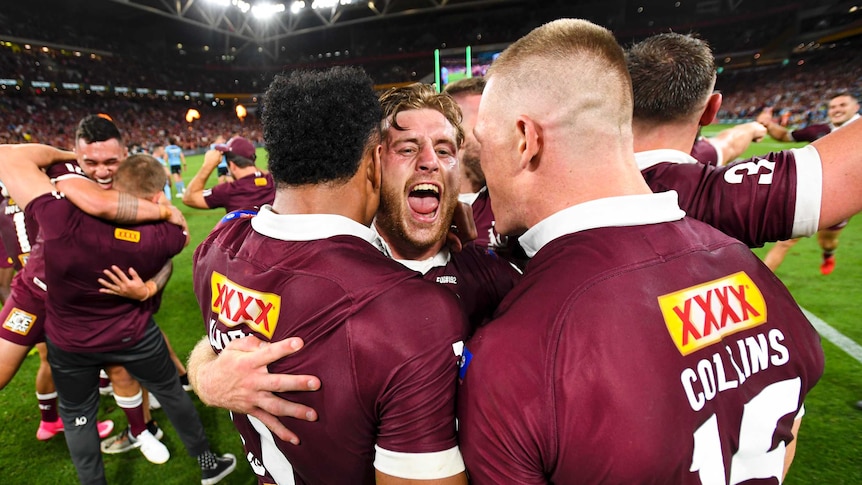 Queensland Maroons stars Cameron Munster, Felise Kaufusi and Lindsay Collins embrace in joy after 2020 State of Origin series.